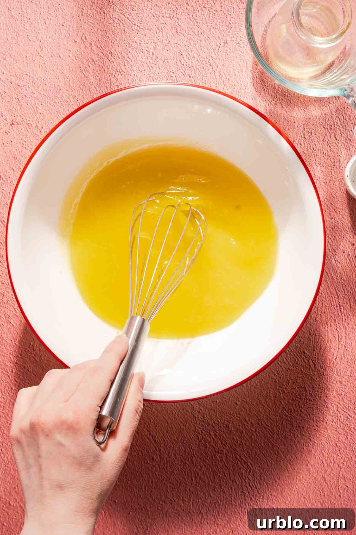 lemon dressing being whisked in a white bowl.