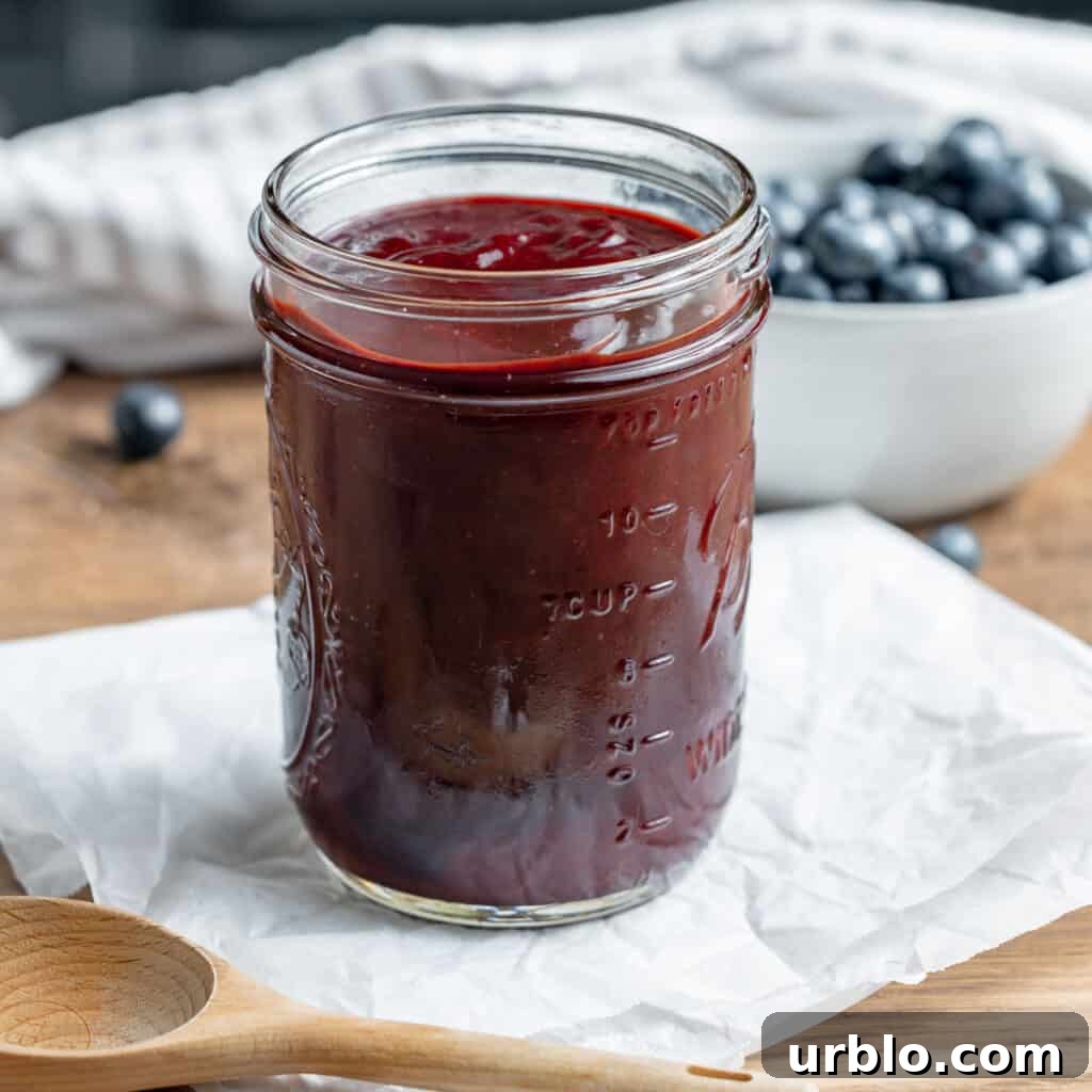 BBQ sauce in a mason jar. Blueberries in the background.