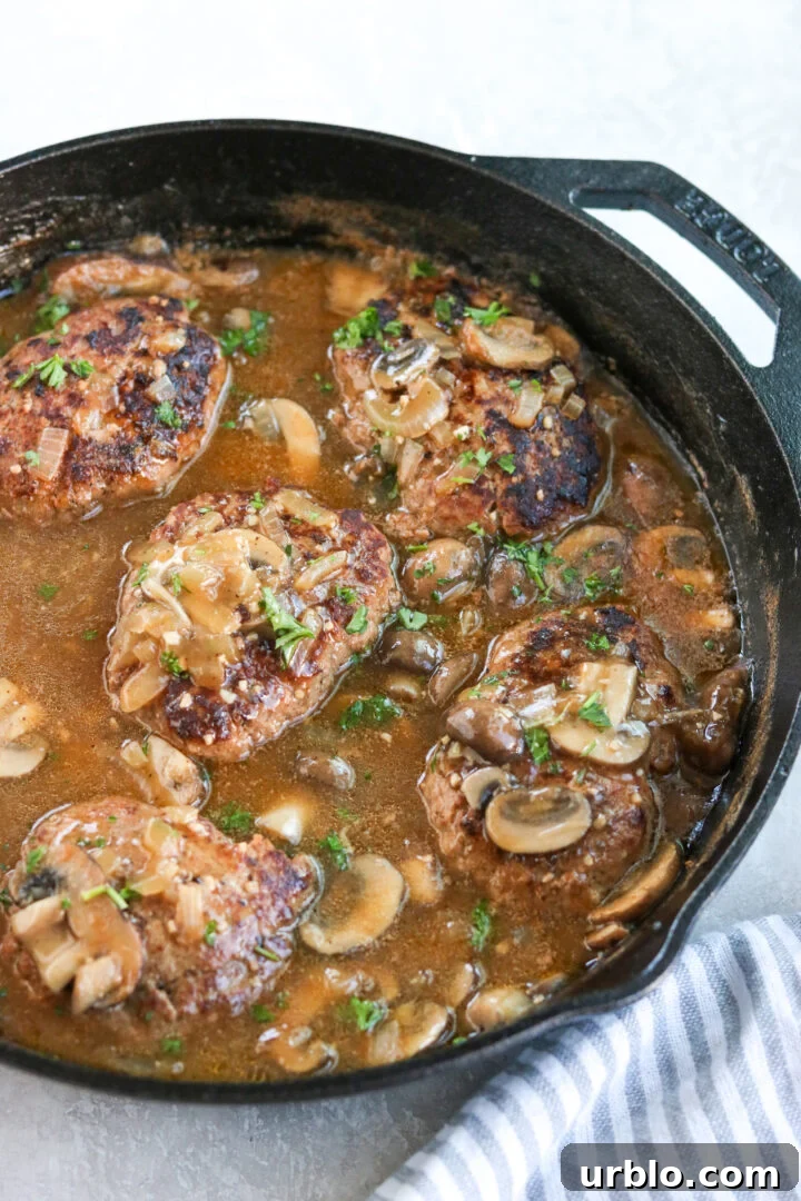 old fashioned salisbury steak with mushroom gravy in a cast iron skillet