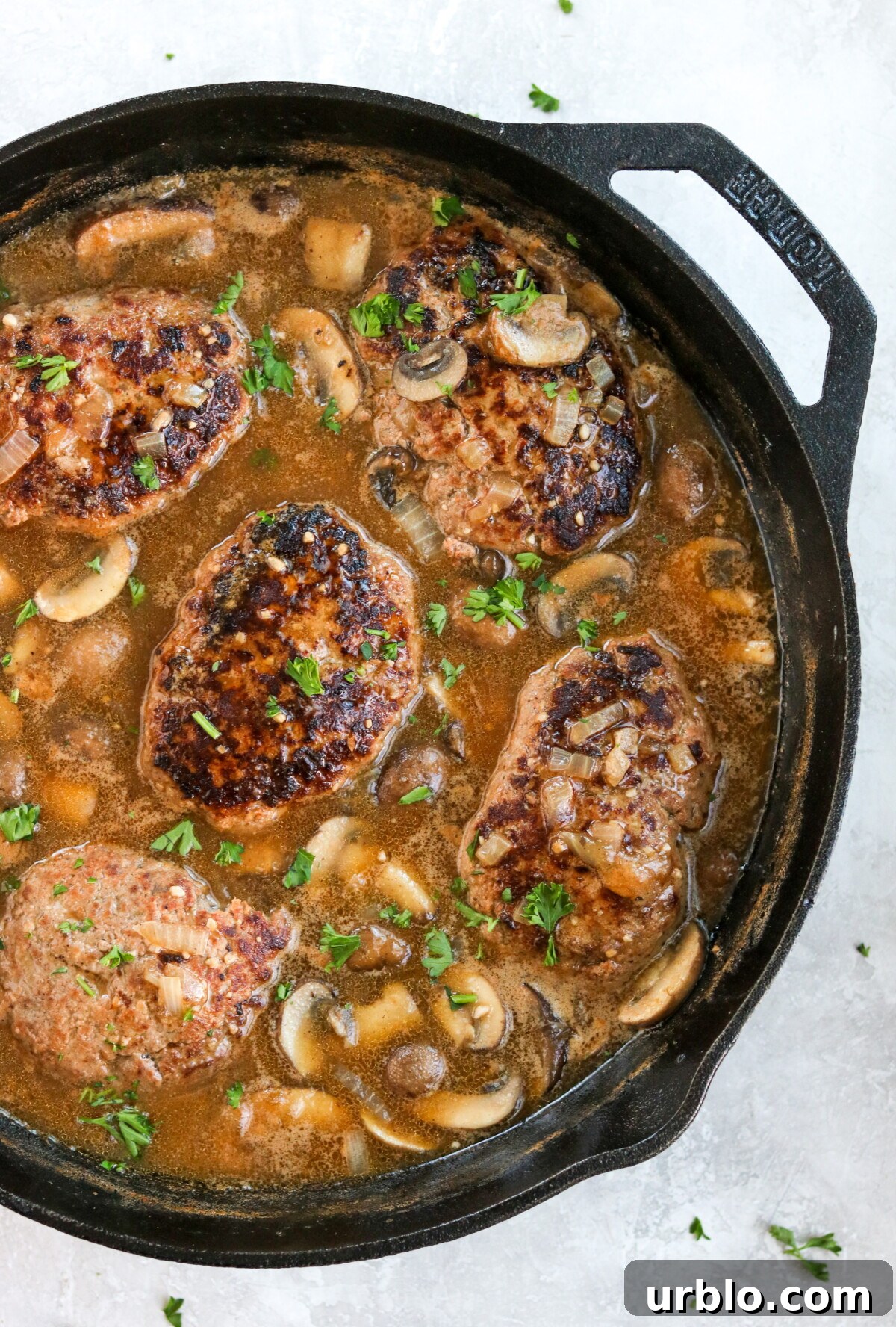 salisbury steak with mushroom gravy in a cast iron pan