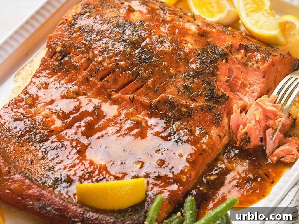 Honey mustard glazed salmon with a glazed seasoning on a white plate.