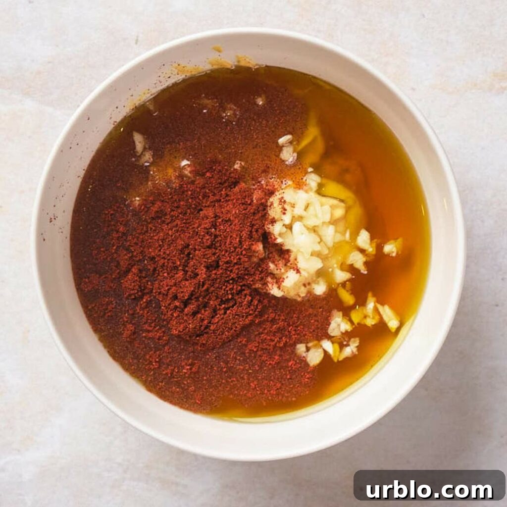 Bowl with oil, minced garlic, and red chili powder.