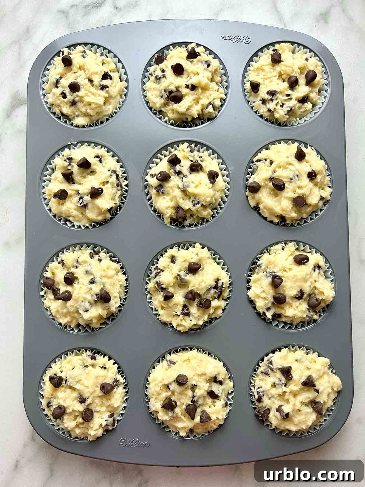 paper liners filled with batter in muffin tray