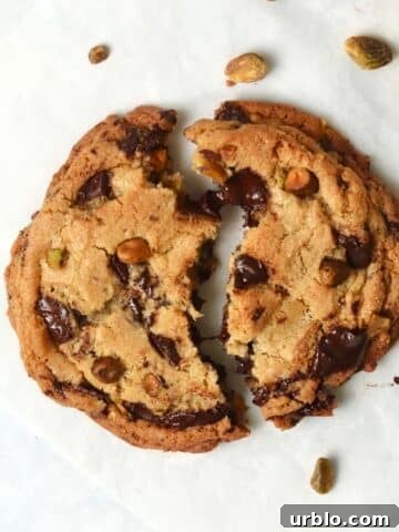 Single serve pistachio chocolate chunk cookie broken in half.