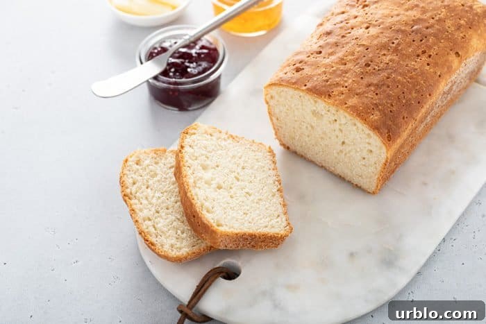 Loaf of english muffin bread set on a marble board, with two slices cut off the end