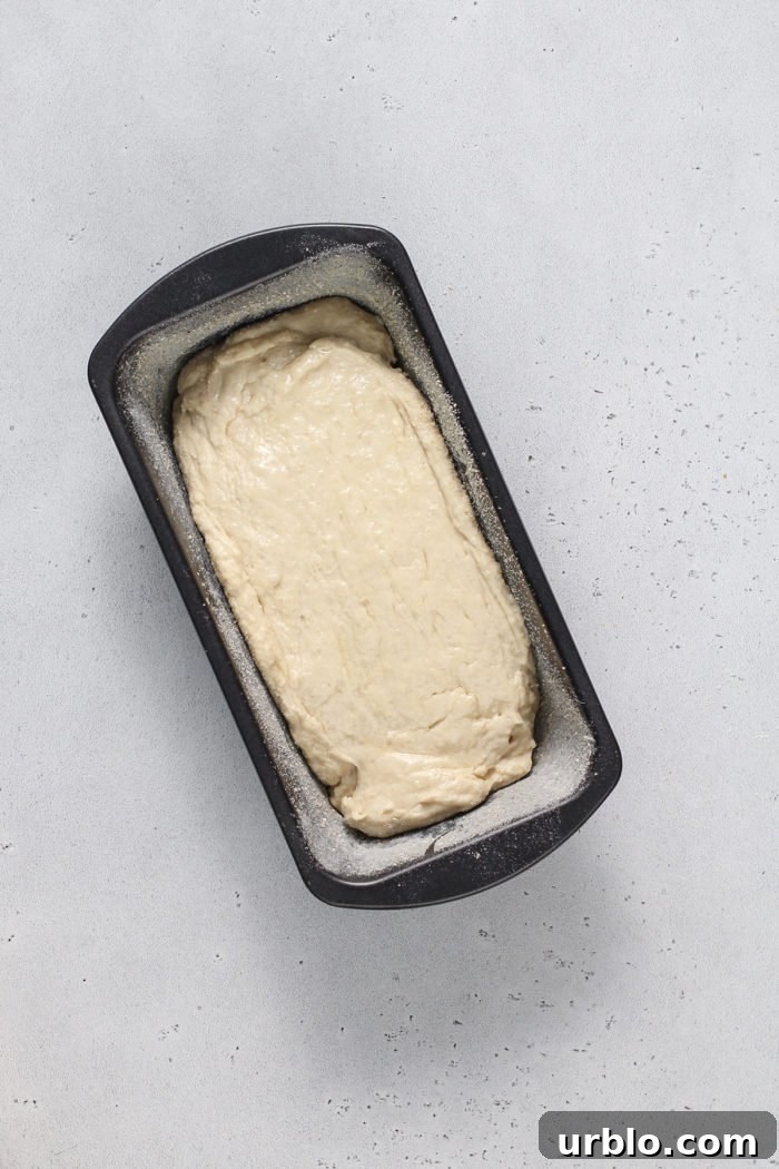 Dough for english muffin bread in a loaf pan, ready to rise