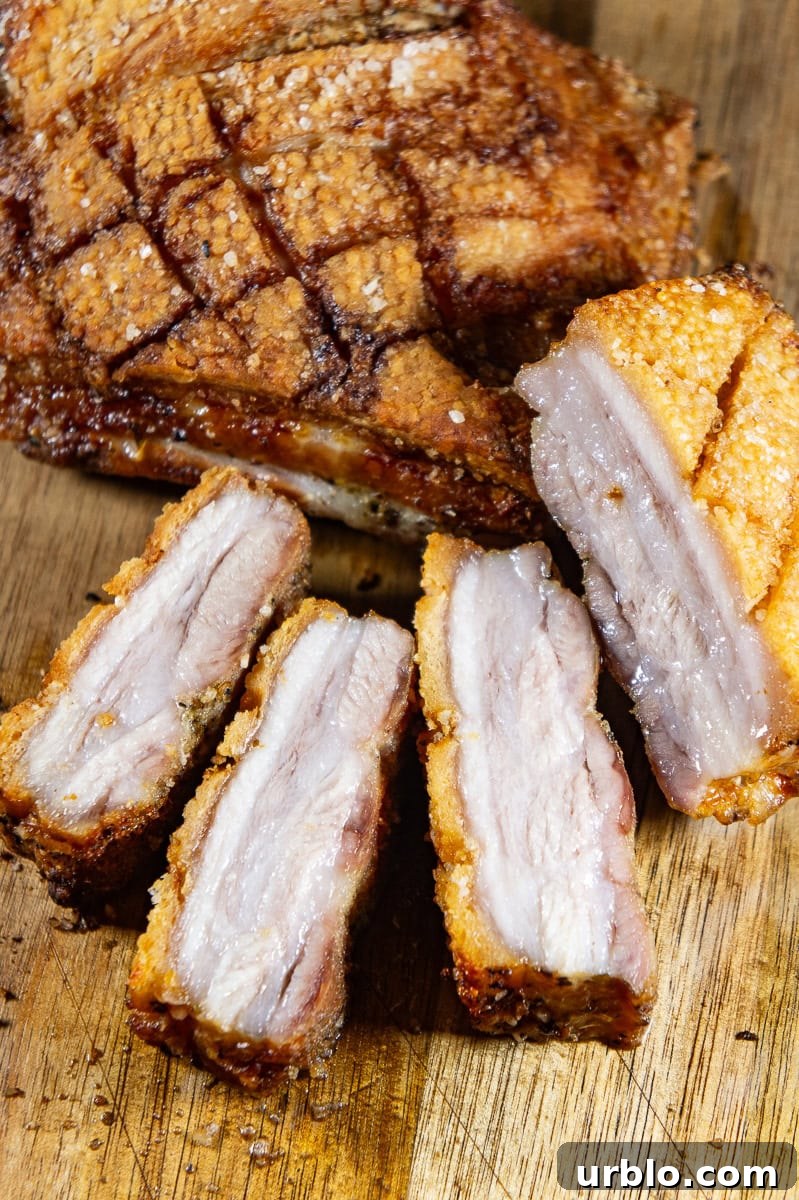Crispy Salt-Crusted Pork Belly Recipe with Tender Juicy Meat 2 a piece of pork belly cooked crisp on top with slices cut from it.