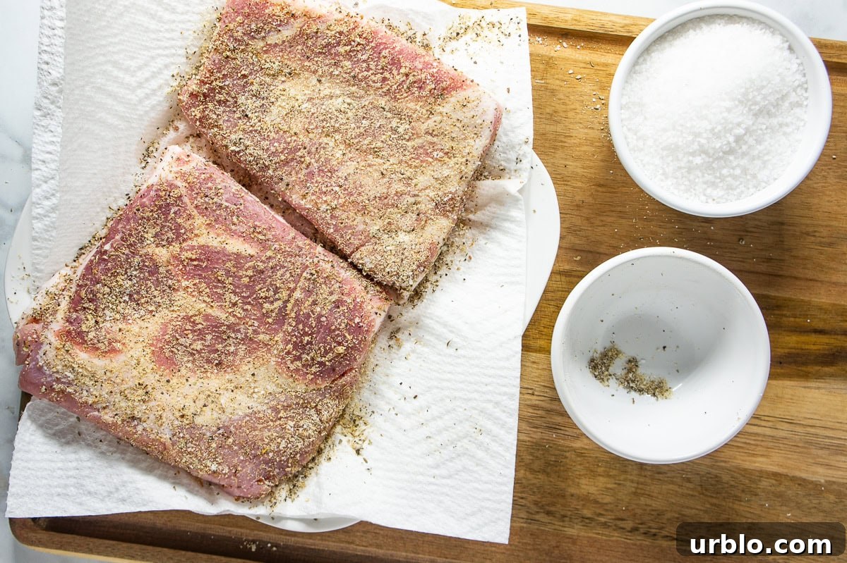 Crispy Salt-Crusted Pork Belly Recipe with Tender Juicy Meat 4 Pork belly rubbed with seasonings on a paper towel.
