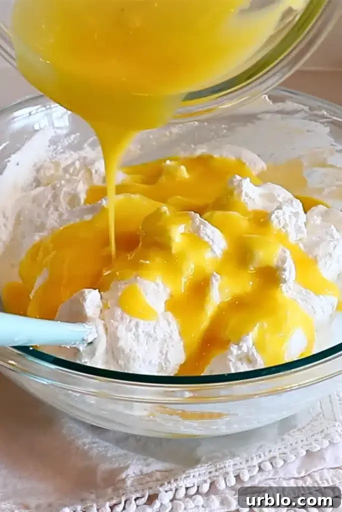 Silky Lemon Mousse Recipe with Fresh Citrus Zest 17 adding the cooled lemon and yolk mixture to the whipped cream and meringue mixture