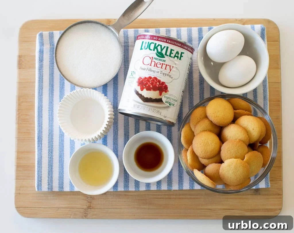 Mini Cherry Cheesecakes Made in a Muffin Tin 5 Ingredients on a wooden board including sugar, cherry pie filling, eggs, vanilla wafers and cupcake liners.