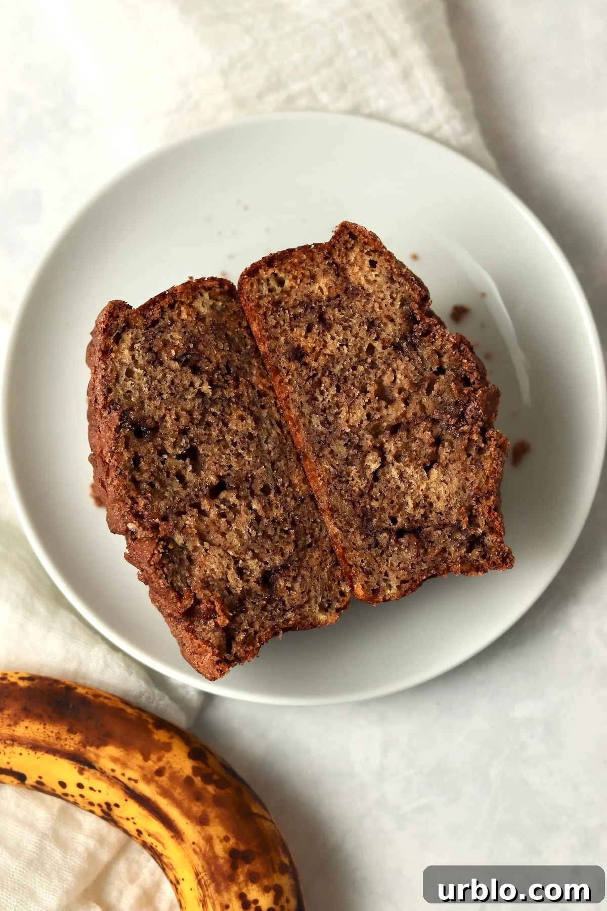 Single-Serve Cinnamon Swirl Banana Bread for One 2 Single Serve Cinnamon Swirl Banana Bread cut in half to show center with a ripe banana.