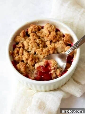 Single-serve rhubarb crisp in a ramekin with a golden oat topping.