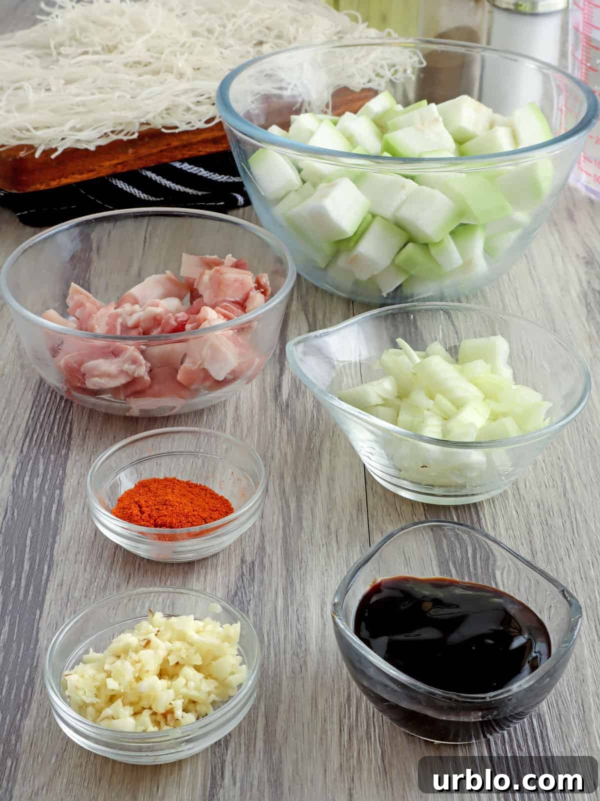 Pancit Upo Recipe: Filipino Bottle Gourd Noodles 3 chopped onions, garlic, diced upo, dry bihon, diced pork belly, oyster sauce, annatto powder in individual bowls