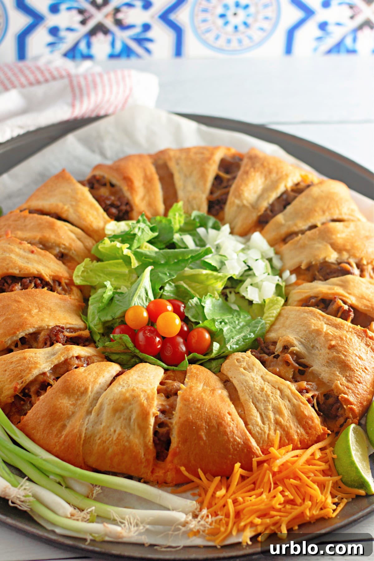 Cheesy Taco Ring with Crescent Roll Crust 2 uncut taco crescent ring on a parchment lined baking sheet.