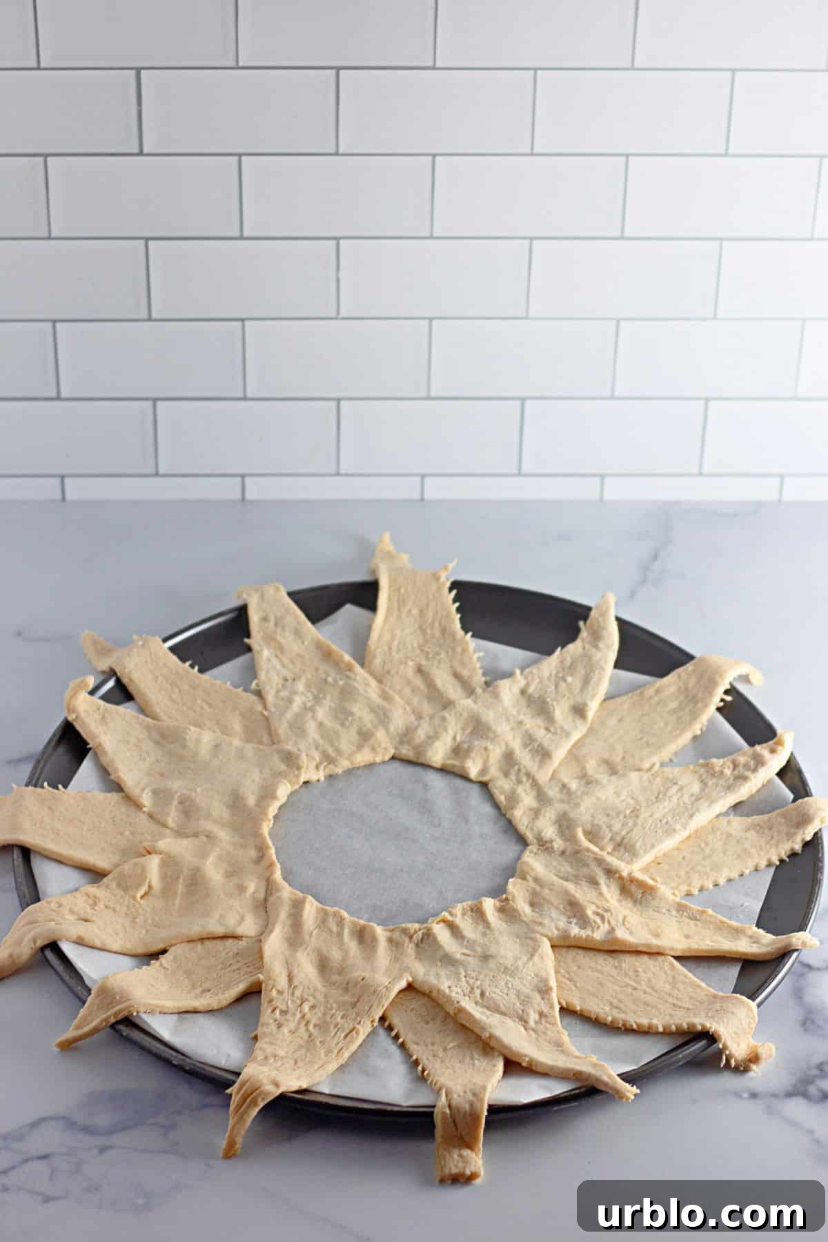Cheesy Taco Ring with Crescent Roll Crust 6 crescents rolls laid out on a parchment lined baking pan in a sun shape.