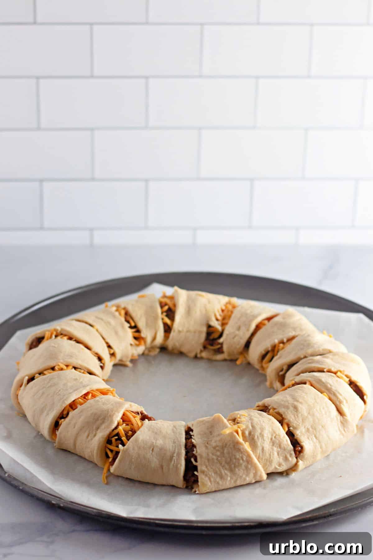 Cheesy Taco Ring with Crescent Roll Crust 7 crescent rolls being wrapped around the crescent ring.