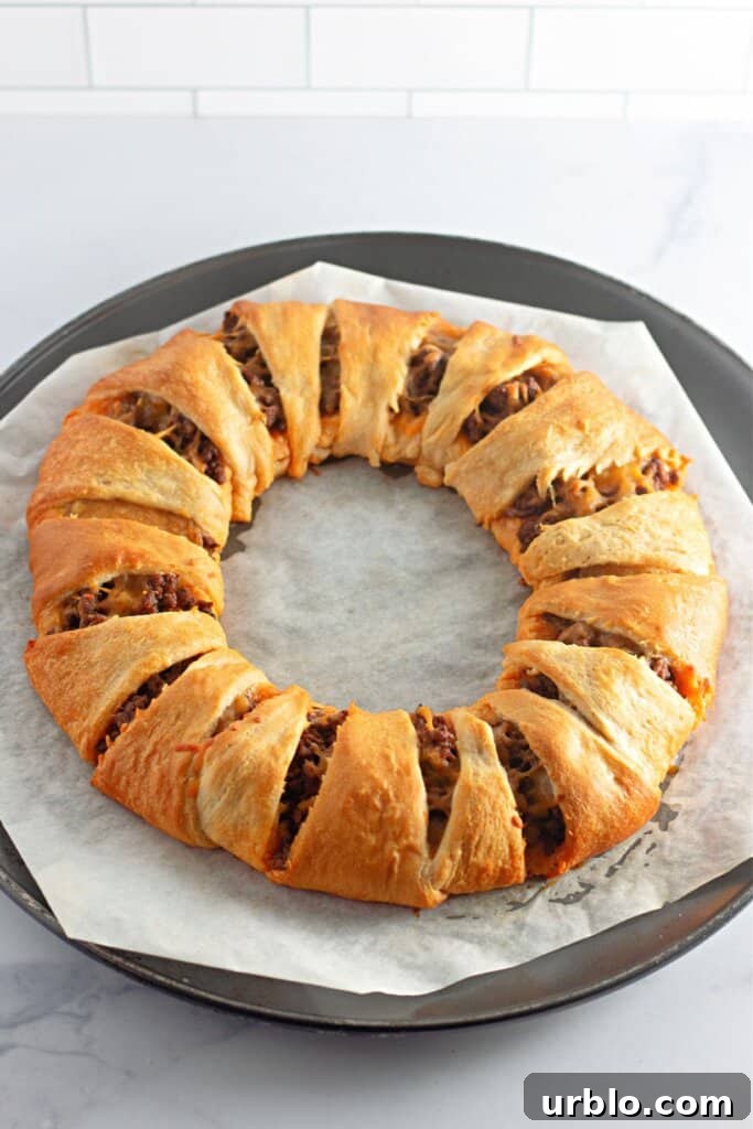 Cheesy Taco Ring with Crescent Roll Crust 8 baked taco crescent ring on a pizza pan.