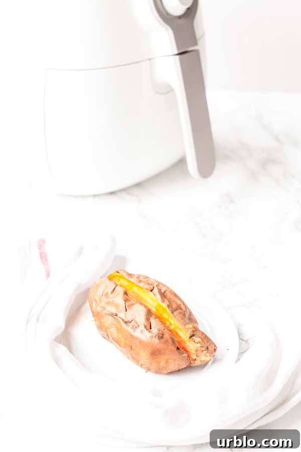Crispy Baked Sweet Potatoes in the Air Fryer 6 baked sweet potato in Air Fryer on a white plate